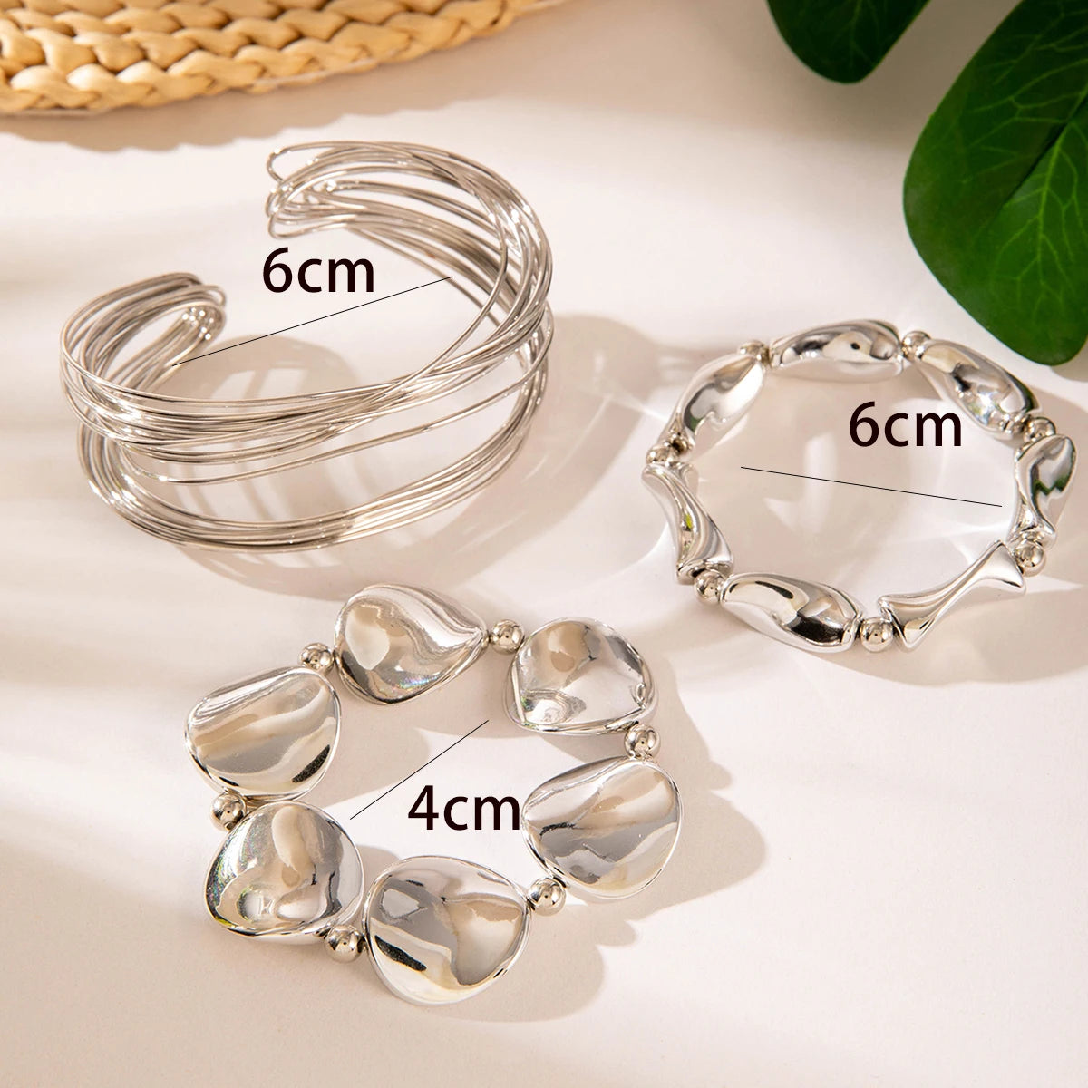 Silver bangles with measurements on a light background