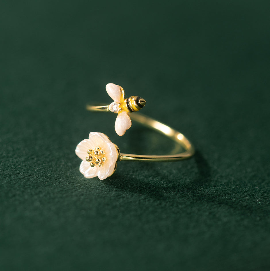 Gold rings with floral designs on a dark green background