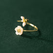 Gold rings with floral designs on a dark green background