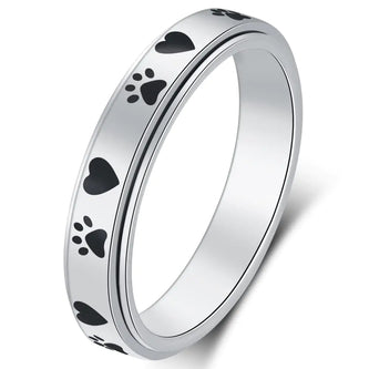 Silver ring with black paw print designs on a white background