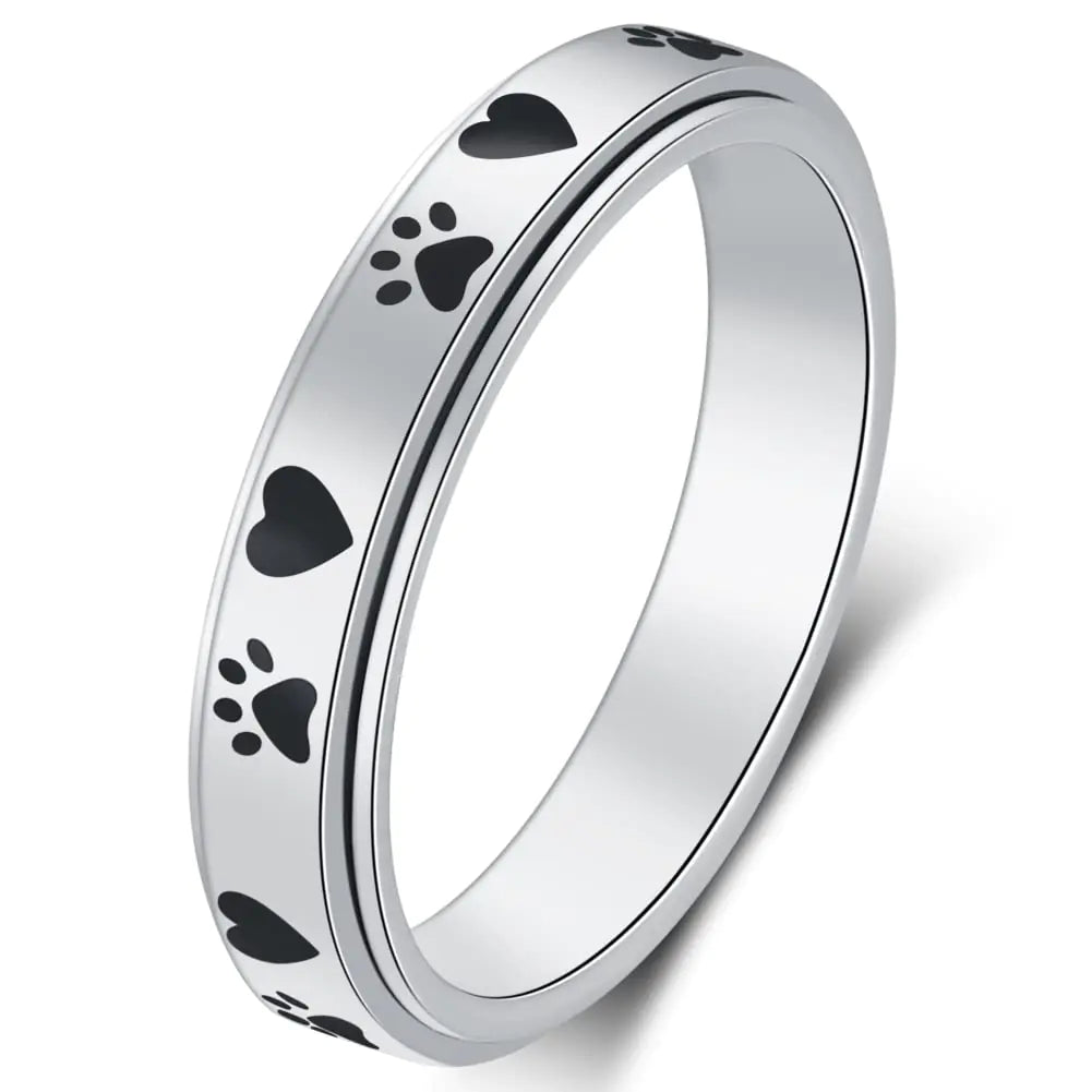Silver ring with black paw print designs on a white background