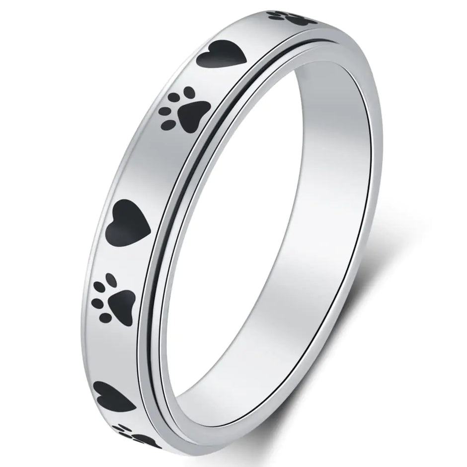 Silver ring with black paw print designs on a white background