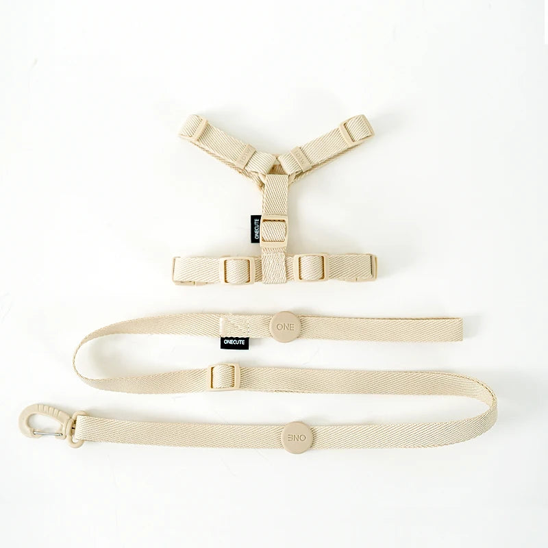 Beige dog harness and leash set on a white background