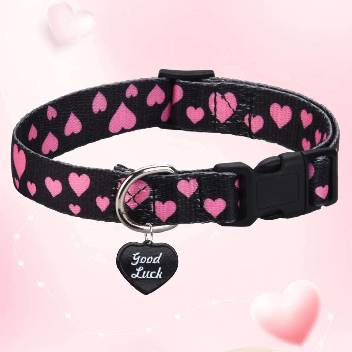 Black dog collar with pink hearts and a 'Good Luck' tag on a pink heart-themed background