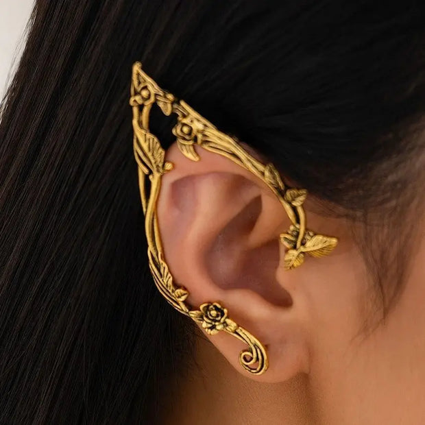 Gold ear cuff worn on an ear with dark hair background
