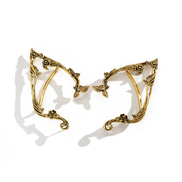 Gold leaf-shaped earrings on a white background