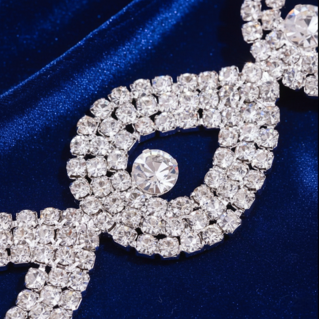 Close-up of a decorative rhinestone belt on a blue fabric background