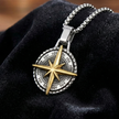 Compass pendant necklace on a black fabric background