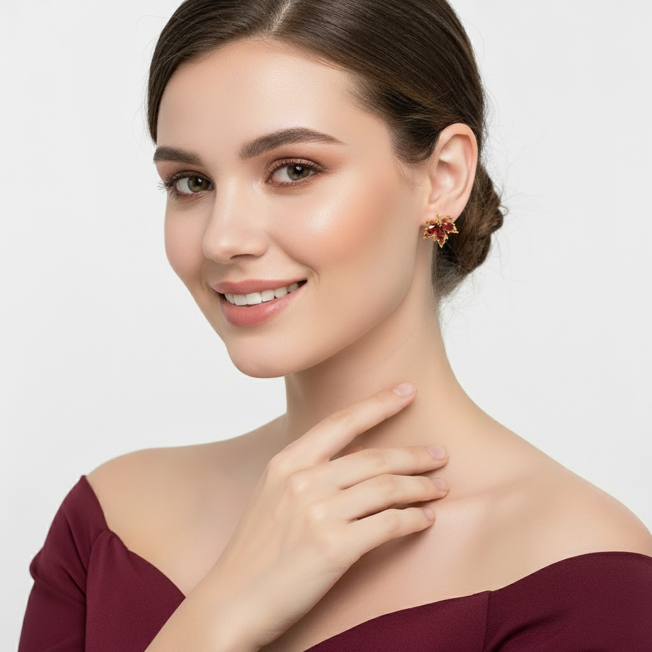 A Woman wearing a pair of Crimson Whisper – Maple Leaf Crystal Studs on a plain background