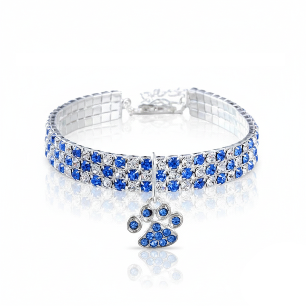 Dog collar with blue and clear gemstones and a paw-shaped charm on a white background