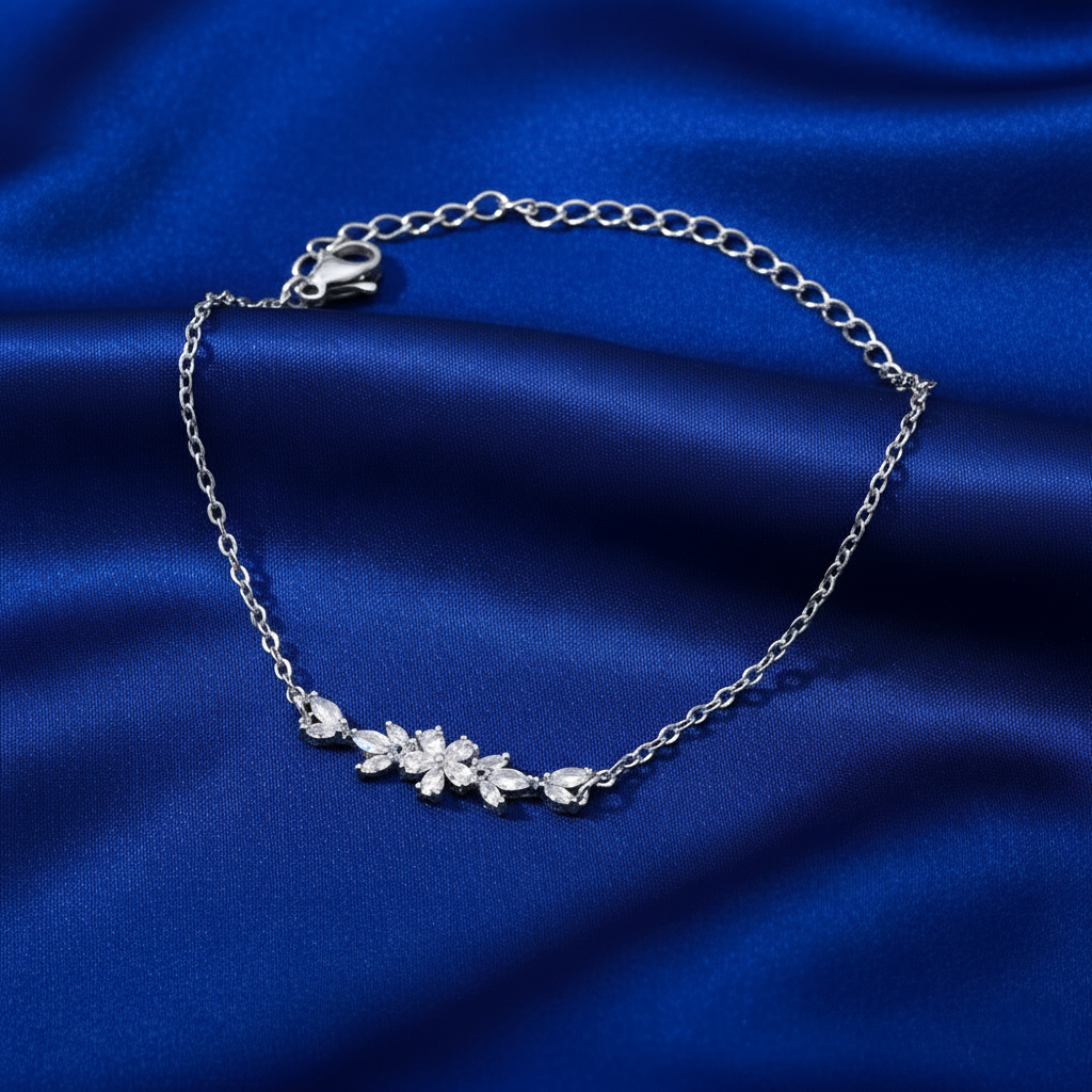 Silver bracelet with a floral design on a blue fabric background