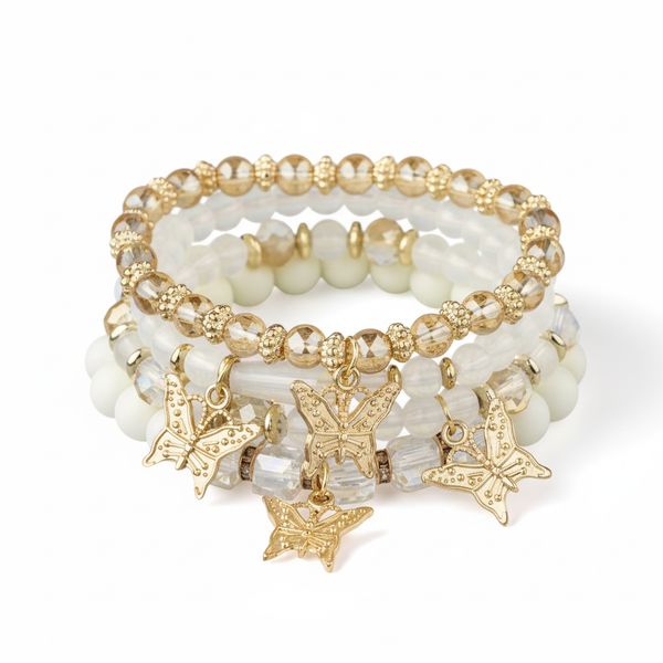 Set of beaded bracelets with butterfly charms on a white background
