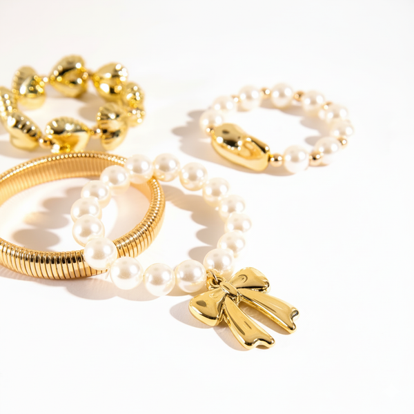Gold and pearl bracelets on a white background