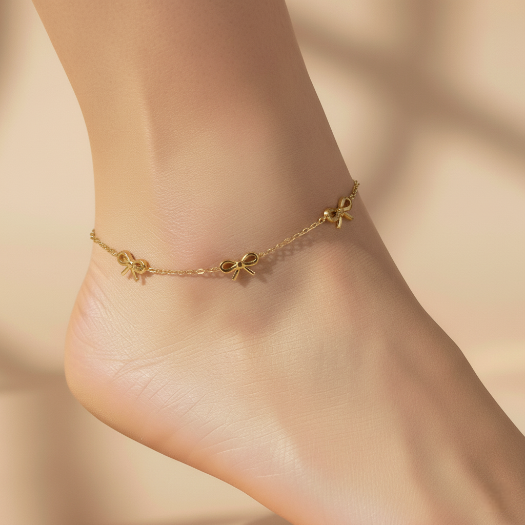 Gold anklet on a person's ankle against a beige background