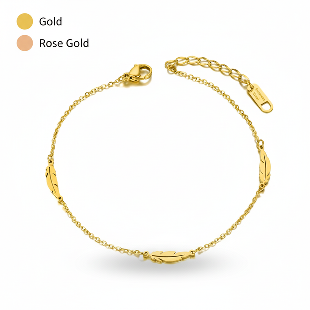 Gold anklet with a feather design on a white background