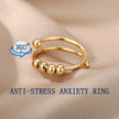 Gold anti-stress anxiety ring on a beige fabric background with '360' logo.