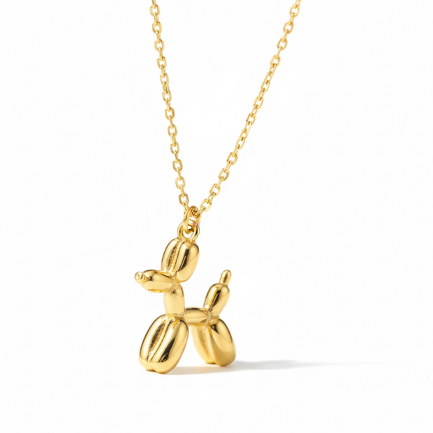 Gold balloon dog necklace on a white background