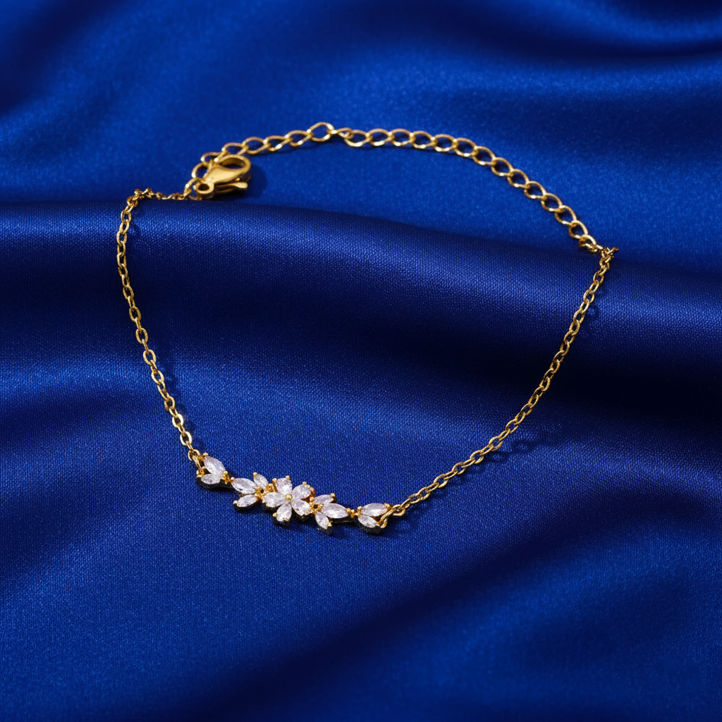 Gold bracelet with a floral design on a blue fabric background