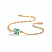 Gold bracelet with a green gemstone on a white background