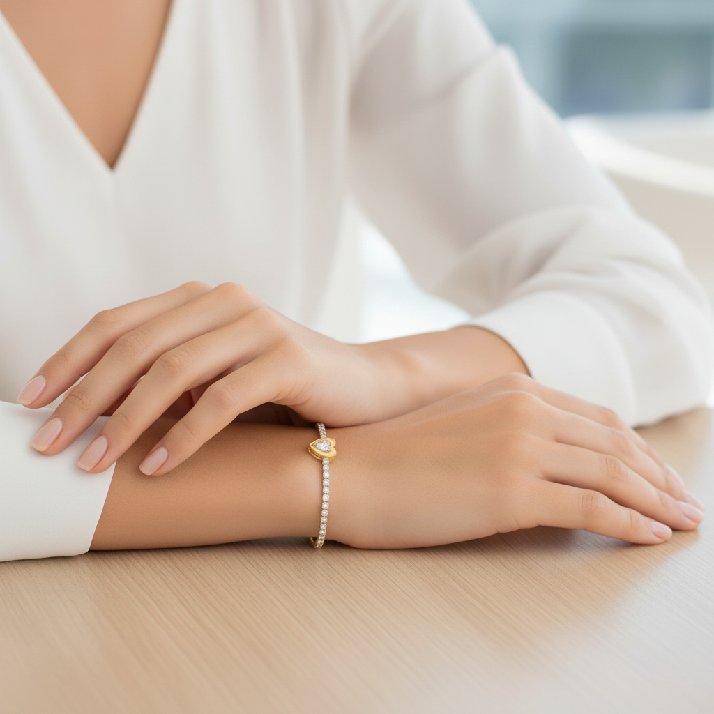 Close-up of a person's wrist wearing a gold bracelet on a light background