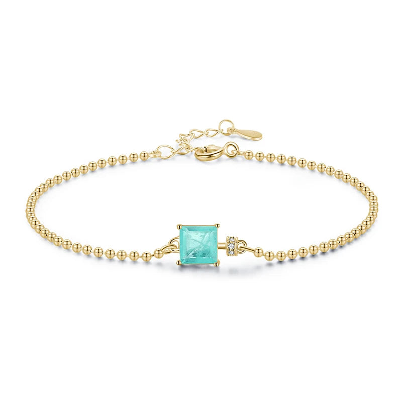 Gold bracelet with a turquoise gemstone on a white background