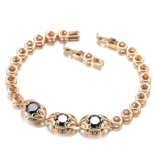 Gold bracelet with black gemstones on a white background