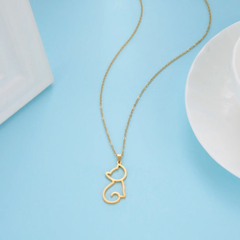 Gold cat-shaped pendant necklace on a light blue background