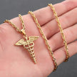 Gold necklace with a caduceus pendant held in a hand against a dark background