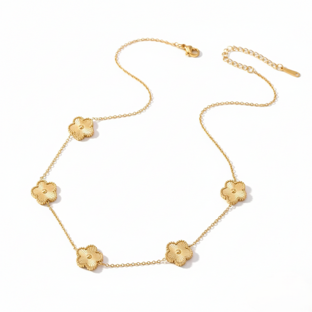 Gold necklace with floral pendants on a white background