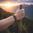 Hand holding a wooden stick with a Green paracord bracelet with a black buckle 