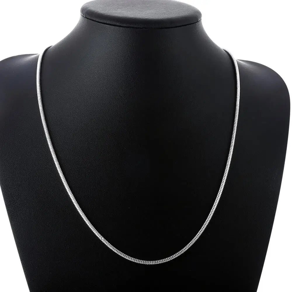 Silver necklace on a black mannequin bust