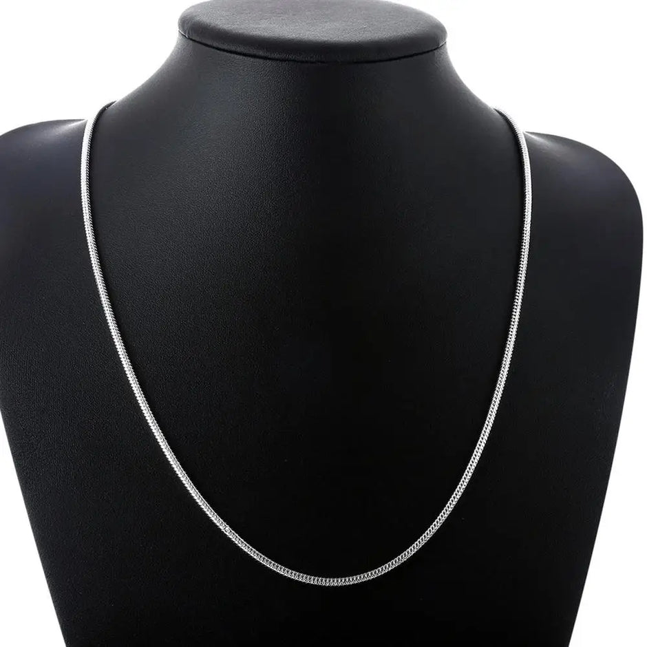 Silver necklace on a black mannequin bust