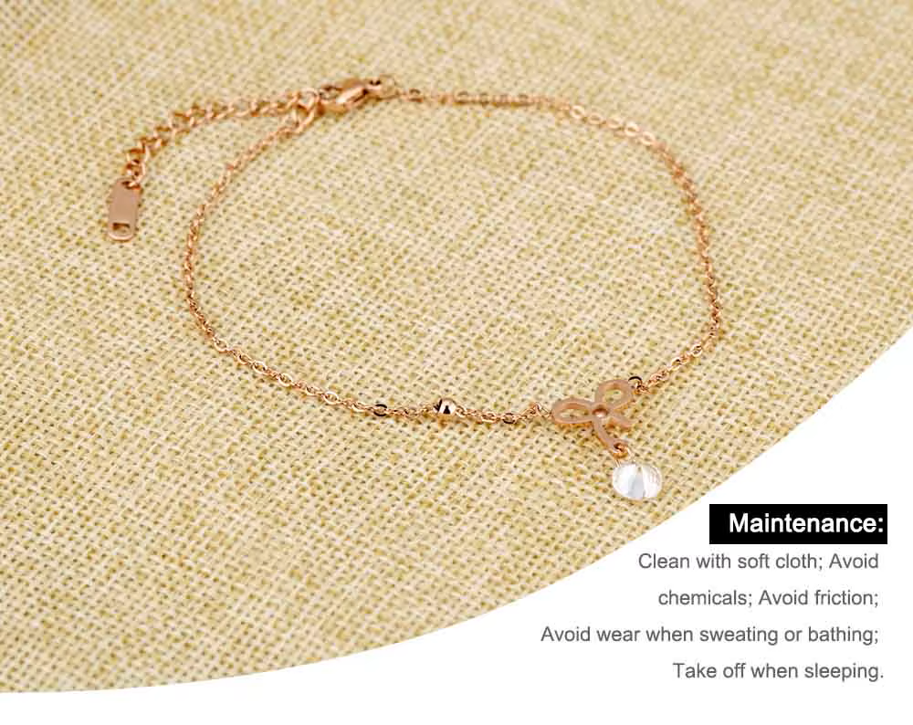 Rose gold anklet on a textured beige surface with maintenance instructions.