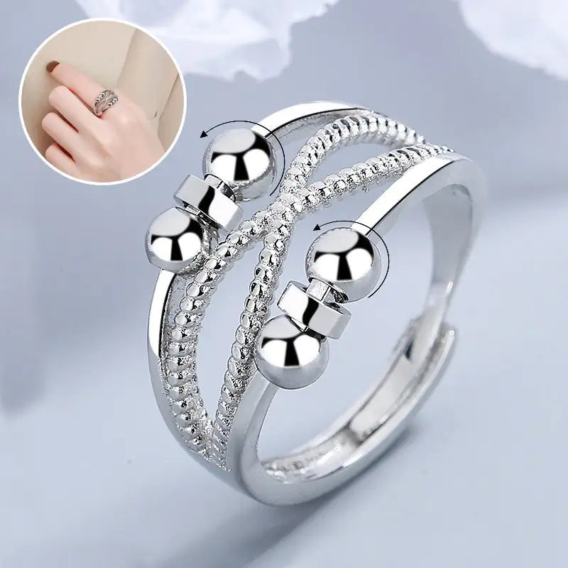 Silver ring with spherical design on a light gray background