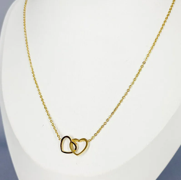 Interlocking hearts pendant necklace worn on neck showing pendant size. Titanium steel love necklace with romantic intertwined hearts design.