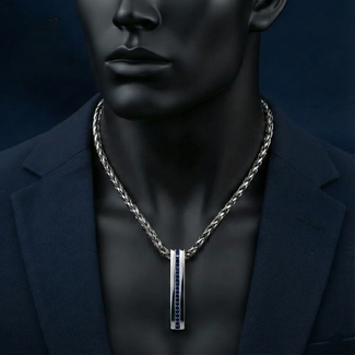 Mannequin wearing a dark suit with a silver necklace and pendant against a black background