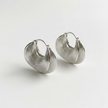 Pair of silver hoop earrings on a light gray background