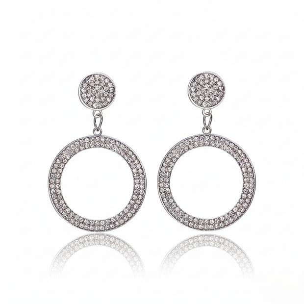 Pair of silver hoop earrings with clear stones on a white background