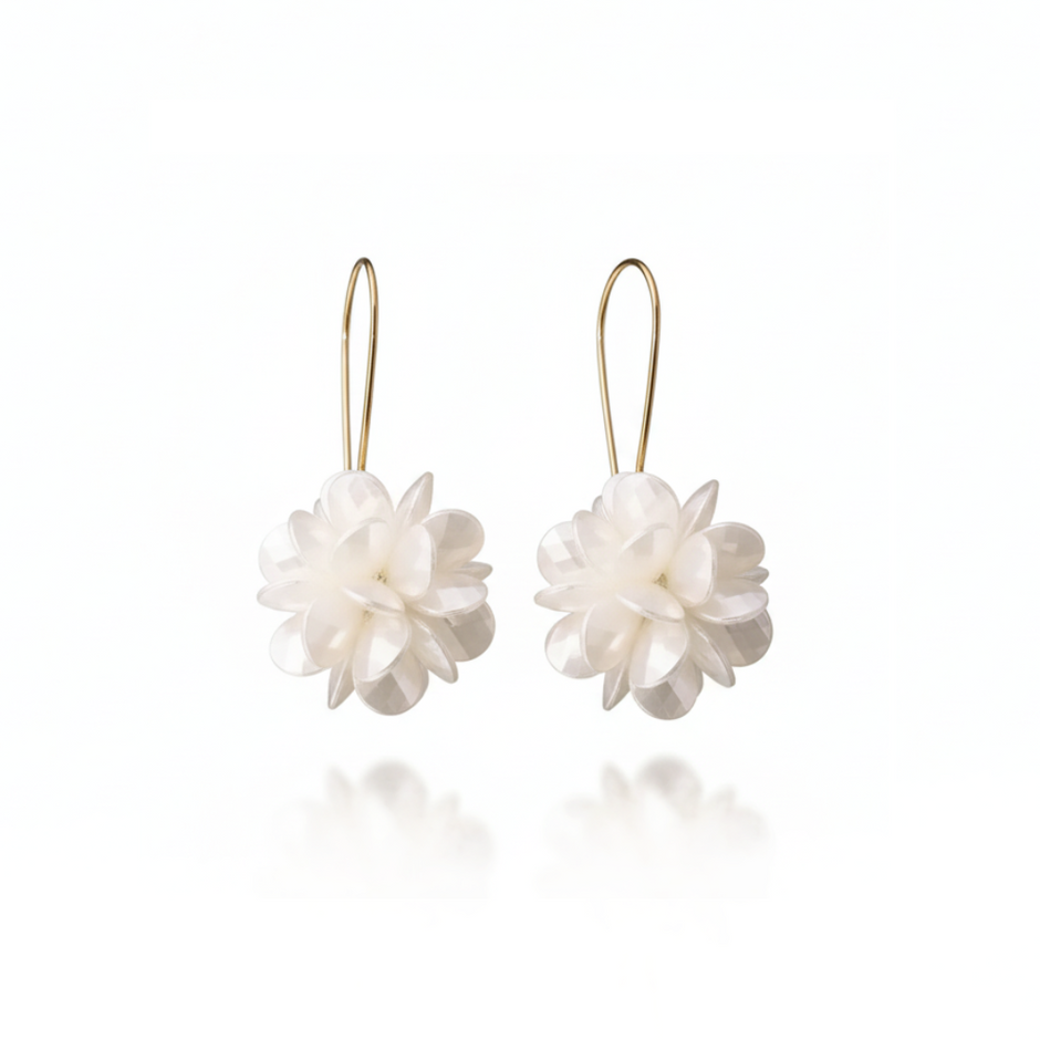 Pair of white floral earrings on gold hooks against a white background
