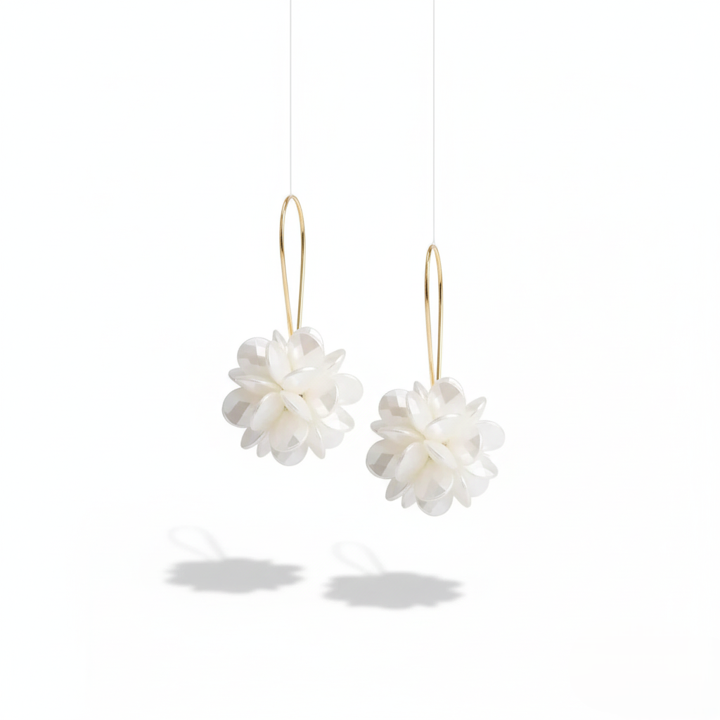 Pair of white floral earrings with gold hooks on a white background