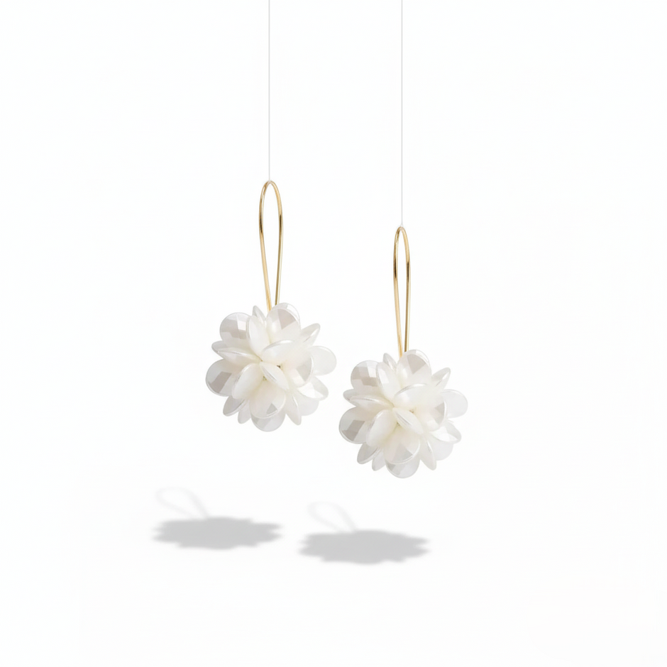 Pair of white floral earrings with gold hooks on a white background