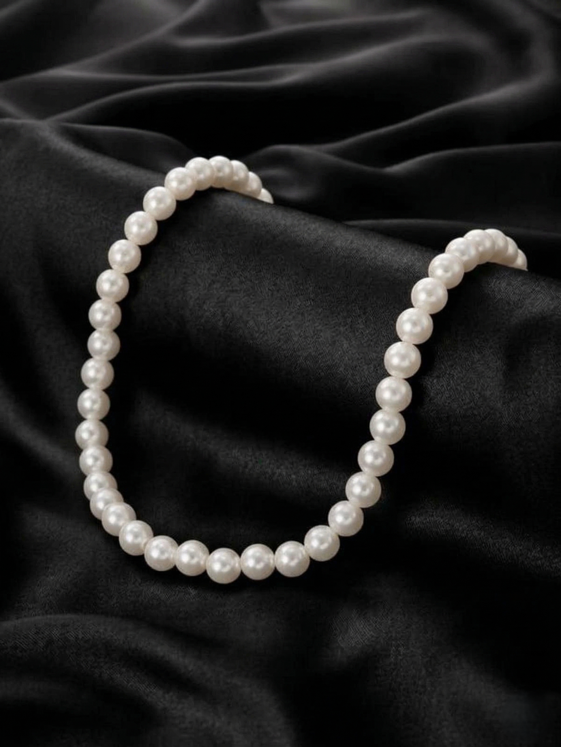 Pearl necklace on a black satin background