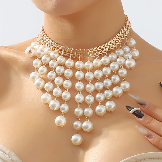Pearl necklace on a mannequin with a gold chain, against a neutral background