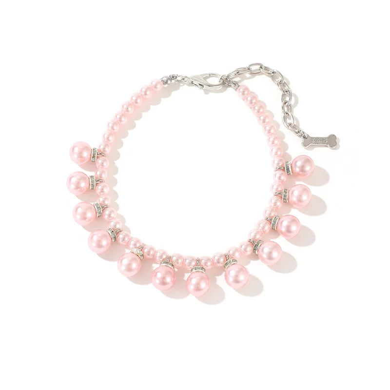 Pink pearl collar with silver charms on a white background