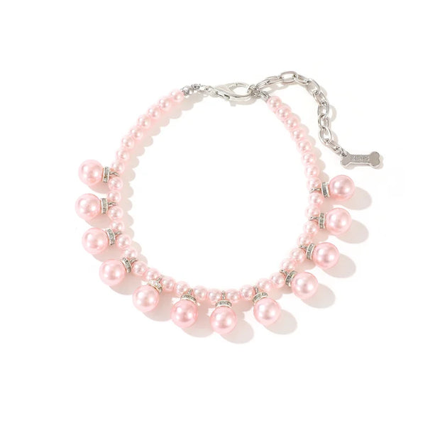 Pink pearl collar with silver charms on a white background