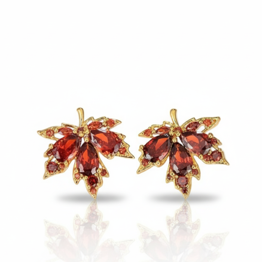 Pair of gold earrings with red gemstones on a white background