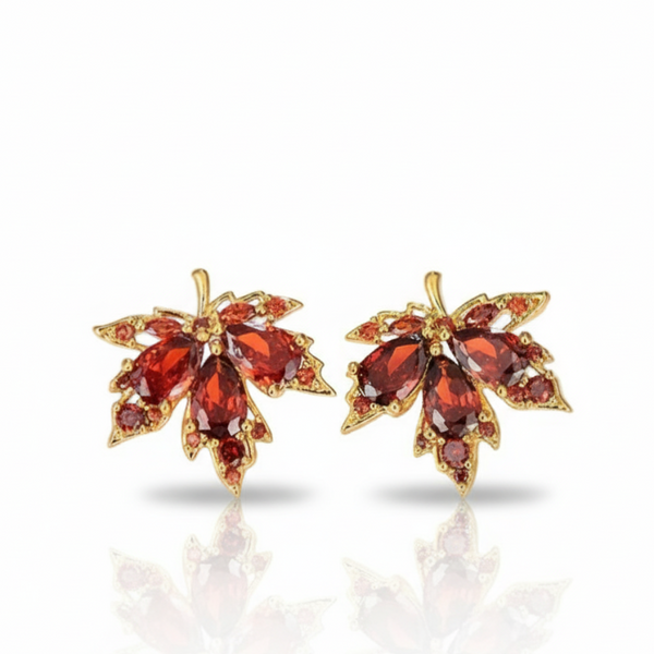 Pair of gold earrings with red gemstones on a white background