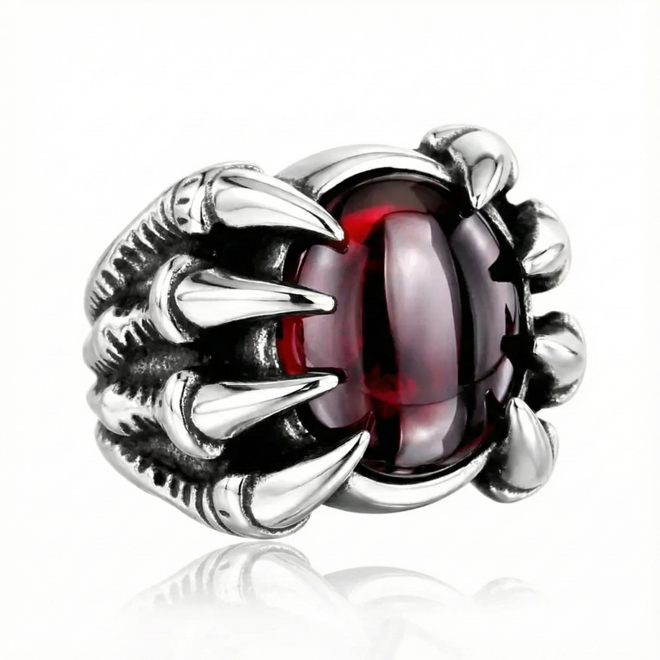 a silver dragon ring with a ruby gemstone on a white background
