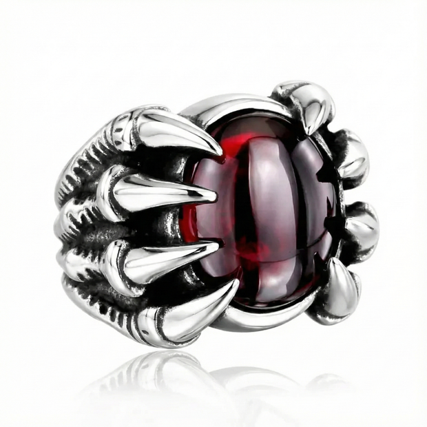 a silver dragon ring with a ruby gemstone on a white background