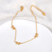 Gold anklet with bow charms on a white background